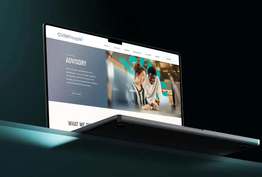 a laptop on a green table with the CVM people website on display