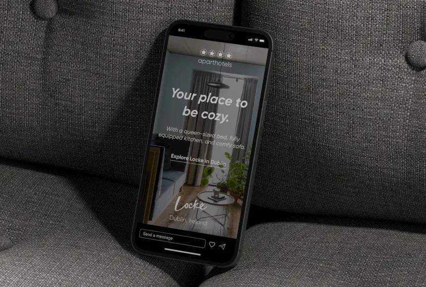 Mobile phone mockup leaning on a dark grey sofa.