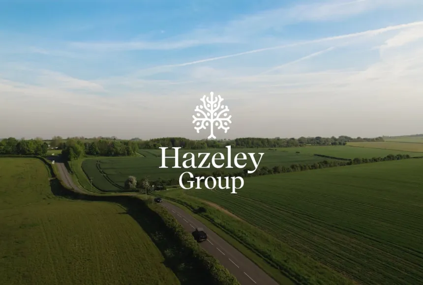 Aerial view of green countryside with the Hazeley Group logo centred over a winding rural road
