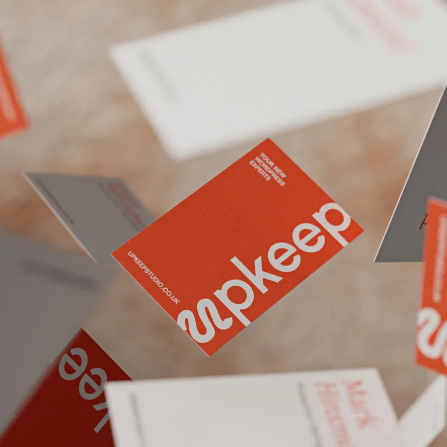 Orange and white Upkeep business cards suspended in the air, scattered across the screen.