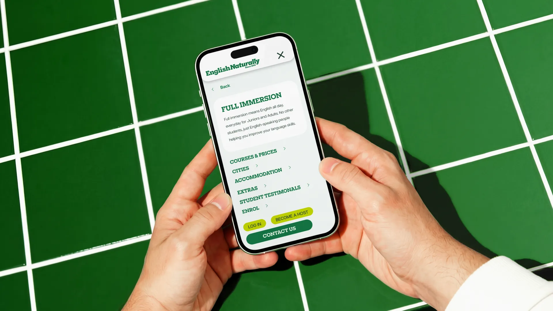 a phone scrolling through a website on a green tiled background